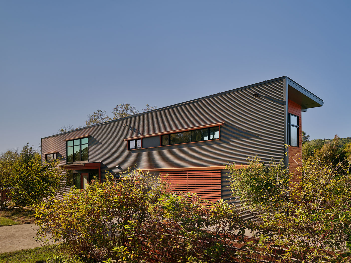 Corrugated Grey Siding with Sliding Garage Doors, Long Glass Windows, Cantilevered Wood Canopy in Charlottesville, VA by Chris Hays Modern Green Architect with HEDS.