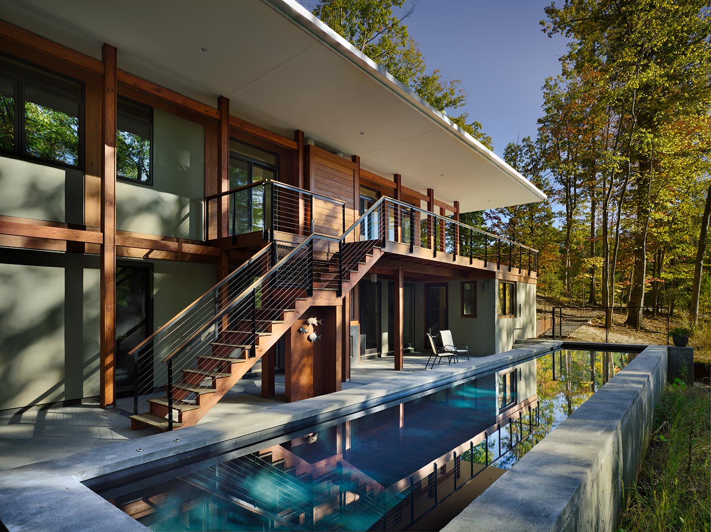 Modern Home has Butterfly Roof that Hovers over Wood Deck and Modern Lap Pool Designed by Charlottesville Architects.