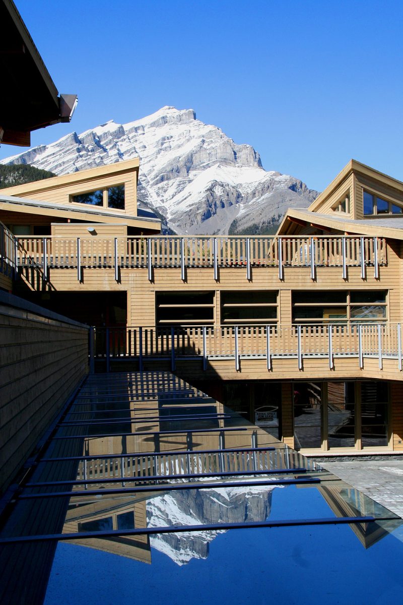 Mixed-Use Commercial and Residential Bison Courtyard at Banff with Glass Canopy and Modern Wood Picket Fence, Cool Eyebrow Windows and Wood Siding by Best Virginia Architects.